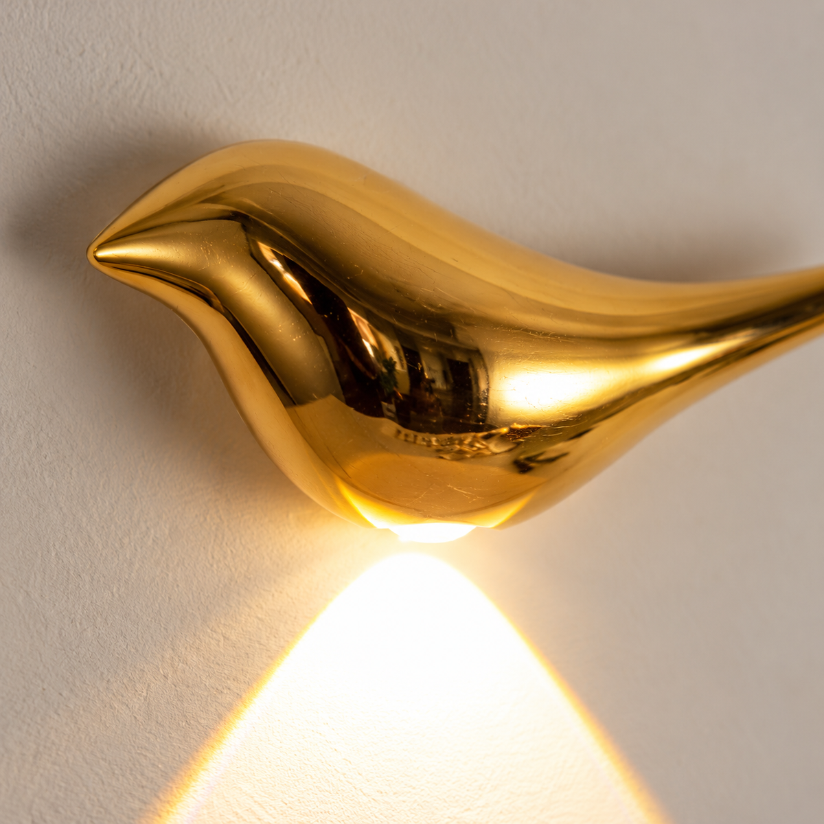 Close-up of the reflective gold bird wall light and concealed lower emitter