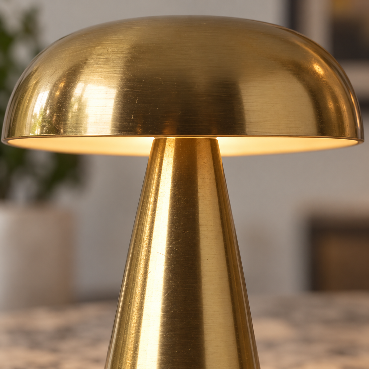 Close-up of the shallow gold shade, illuminated underside and conical body