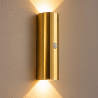 Close-up of the faceted gold body and round motion sensor on the wall light