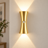 Gold hourglass motion sensor wall light casting warm light up and down