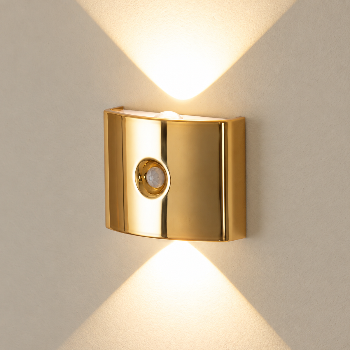Gold rechargeable motion sensor wall light mounted and switched on against a light wall