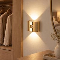 Gold cordless sensor light mounted beside a bedroom doorway at dusk