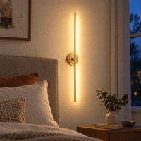 Gold rechargeable vertical wall light mounted beside a bedroom headboard