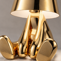 Close-up of the gold seated figure lamp body and shade finish