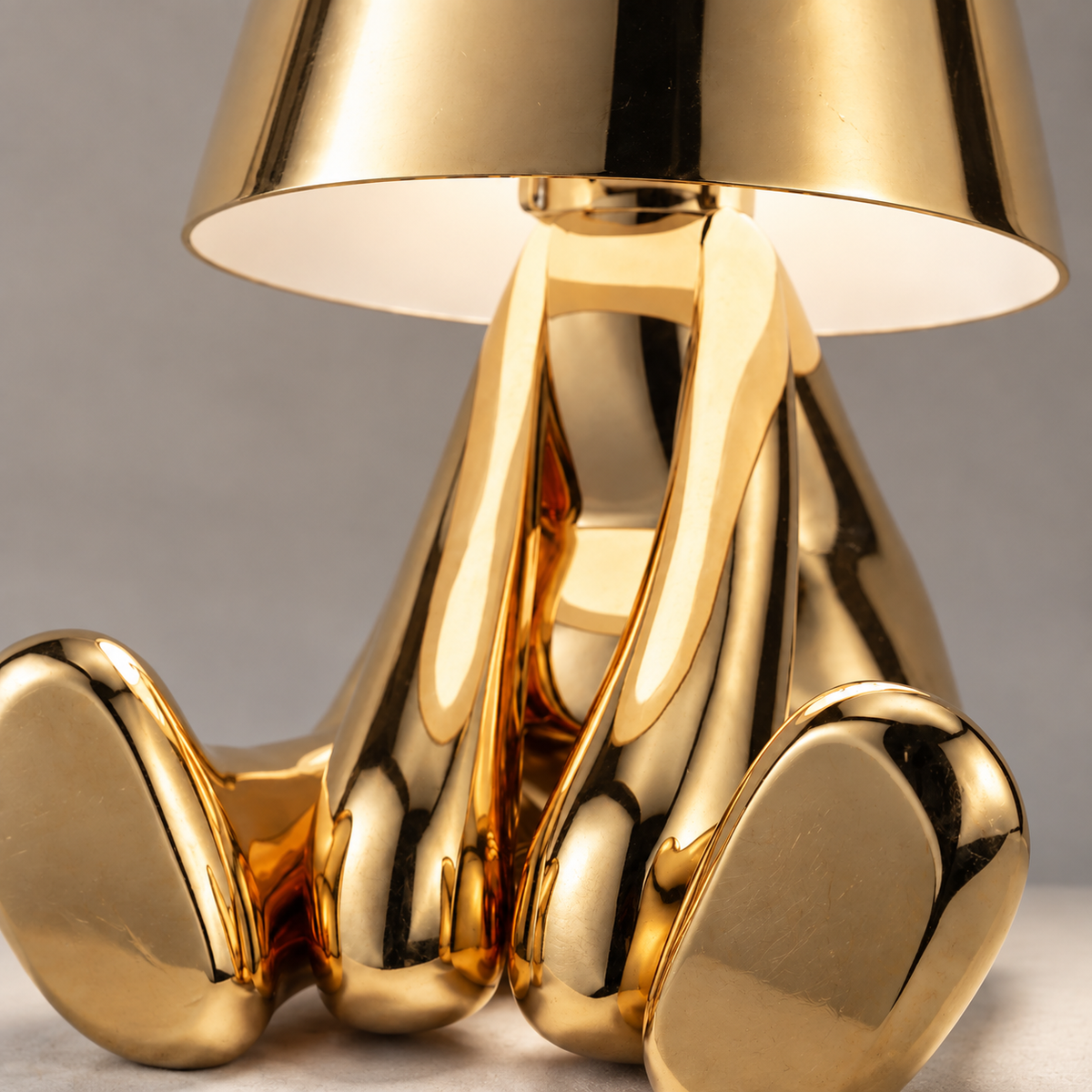 Close-up of the gold seated figure lamp body and shade finish