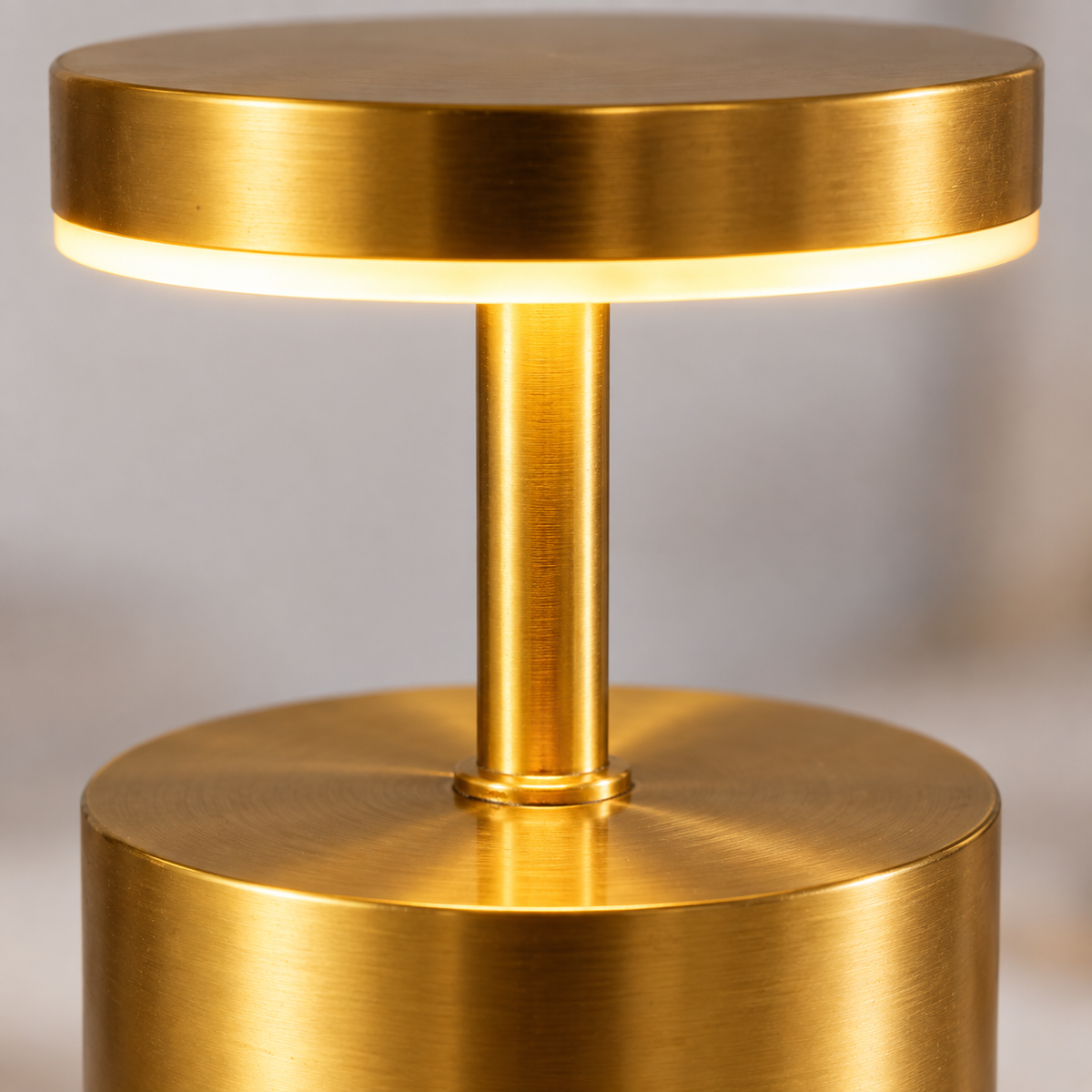 Close-up of the satin gold lamp head, illuminated ring and stem joint